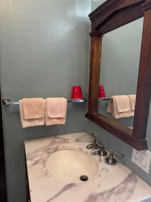a bathroom with a marble sink and a mirror at Country Road Motor Inn