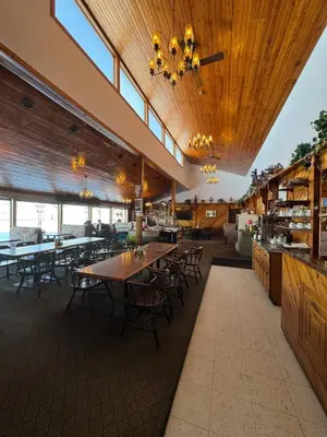 a restaurant with wooden ceilings and tables and chairs at Country Road Motor Inn
