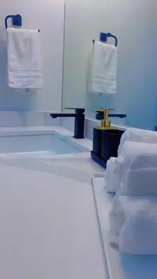 a bathroom with a tub and a mirror and towels at Brand New cozy apartment bright, modern private 2 bedroom basement! in Calgary