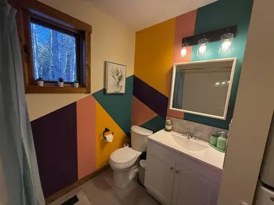 a colorful bathroom with a toilet and a sink at Private 2BR Forest Suite in Bragg Creek with Hot tub, pond, 17 acres of trails in Bragg Creek