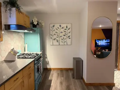 a kitchen with a stove and a sink and a mirror at Private 2BR Forest Suite in Bragg Creek with Hot tub, pond, 17 acres of trails in Bragg Creek