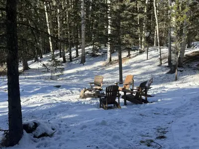 a group of chairs sitting around a table in the snow at Private 2BR Forest Suite in Bragg Creek with Hot tub, pond, 17 acres of trails in Bragg Creek