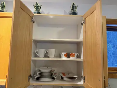 a cupboard with plates and cups and dishes in it at Private 2BR Forest Suite in Bragg Creek with Hot tub, pond, 17 acres of trails in Bragg Creek