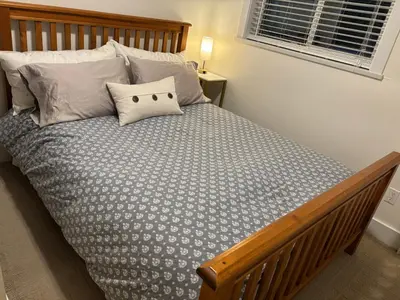 a bedroom with a bed with a wooden frame and pillows at Sumas Mountain basement suite in Abbotsford