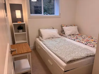 a small bedroom with a bed and a window at Sumas Mountain basement suite in Abbotsford