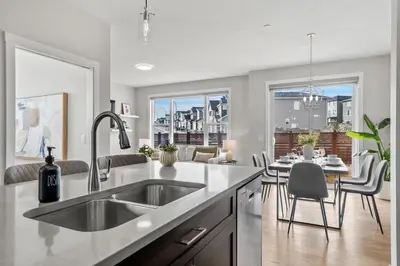 a kitchen with a sink and a dining room at Herron Rise Luxury 4 Bedroom Main Floor in Calgary