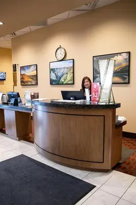 a woman sitting at a reception desk in a lobby at Hotel 11, MOD A Sonesta Collection in Calgary