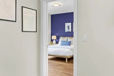 a bedroom with a bed and a blue wall at Tranquil 2BR Golden Oasis BBQ, Balcony, MTN Views in Golden