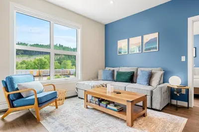 a living room with a couch and a table at Brand New 2BR Oasis Mins to DT with AC Balcony and BBQ in Golden