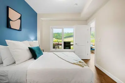 a bedroom with a large white bed with blue walls at Brand New 2BR Oasis Mins to DT with AC Balcony and BBQ in Golden