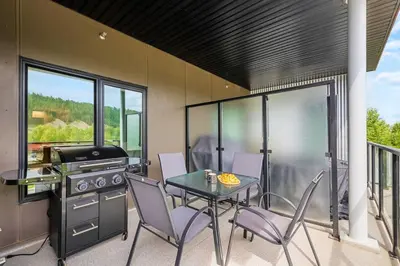 a patio with a table and chairs and a grill at Brand New 2BR Oasis Mins to DT with AC Balcony and BBQ in Golden