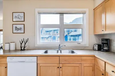 a kitchen with a sink and a window at Cozy 2 BR Condo plus Gym with Stunning Mountain View in Canmore