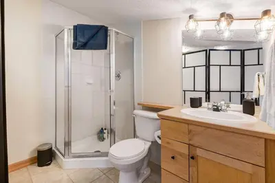 a bathroom with a shower and a toilet and a sink at Cozy 2 BR Condo plus Gym with Stunning Mountain View in Canmore