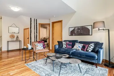 a living room with a blue couch and two tables at Cozy 2 BR Condo plus Gym with Stunning Mountain View in Canmore