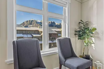 two chairs sitting in a room with a window at Mountain View Retreat Elegant 3BR condo with Gym in Canmore