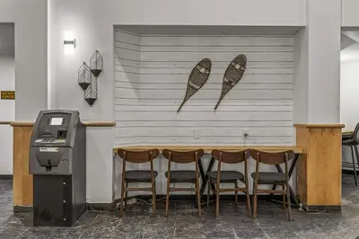 a table with four chairs next to a wall with surfboards at Mountain View Retreat Elegant 3BR condo with Gym in Canmore