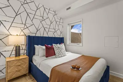 a bedroom with a king sized bed with a blue headboard at Rockies Getaway Condo With Mountain View in Canmore