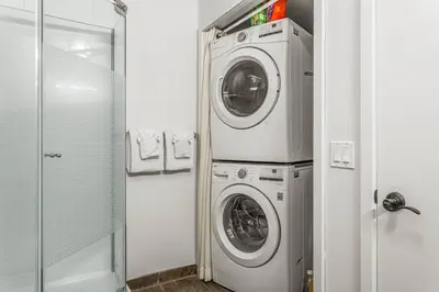 a laundry room with a washer and dryer in it at Rockies Getaway Condo With Mountain View in Canmore