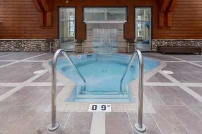 a hot tub in the middle of a house at Rockies Getaway Condo With Mountain View in Canmore