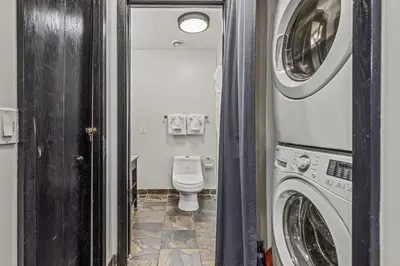 a bathroom with a toilet and a washer and dryer at Renovated Haven in Rockies with Hot Tub and Pool in Canmore