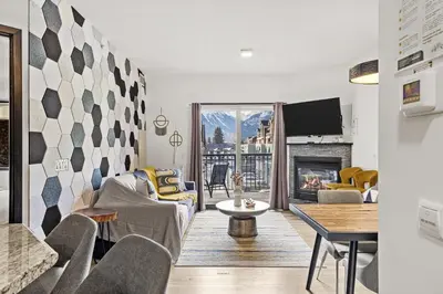 a living room with a couch and a table at Splendid Mountain View 2BR Condo with Pool and Hot Tub in Canmore
