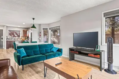 a living room with a blue couch and a tv at 2BR Bow Valley Retreat with BBQ Near Parks and Banff in Canmore