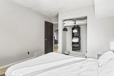 a white bedroom with a bed and a closet at 2BR Bow Valley Retreat with BBQ Near Parks and Banff in Canmore
