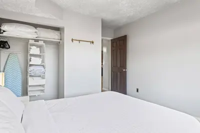 a white bedroom with a bed and a closet at 2BR Bow Valley Retreat with BBQ Near Parks and Banff in Canmore