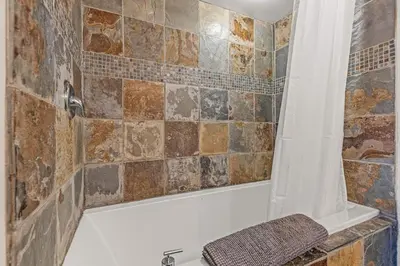 a bathroom with a shower with a bath tub at Relaxing 1BR Getaway Hot tub plus Amazing Mtn Views in Canmore