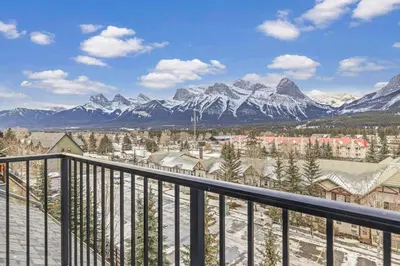 a view from the balcony of a resort with snow covered mountains at Relaxing 1BR Getaway Hot tub plus Amazing Mtn Views in Canmore
