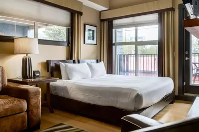 a hotel room with a bed and a window at Cozy Rocky Mountain Studio with Hot tub and Gym in Canmore