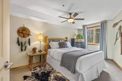 a bedroom with a bed and a ceiling fan at Rustic Creekside Retreat 2BR with Stunning View in Canmore