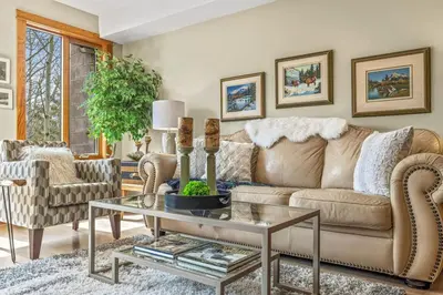 a living room with a couch and a table at Rustic Creekside Retreat 2BR with Stunning View in Canmore