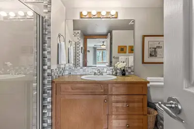 a bathroom with a sink and a mirror at Rustic Creekside Retreat 2BR with Stunning View in Canmore