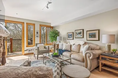 a living room with a couch and a table at Rustic Creekside Retreat 2BR with Stunning View in Canmore