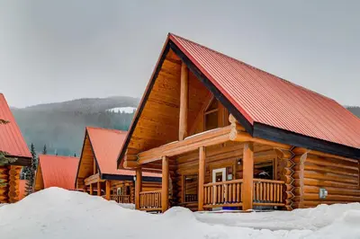 a log cabin with a red roof in the snow at Beautiful Rustic Chalet in the Heart of Rockies in Golden
