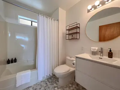 a bathroom with a toilet and a sink and a mirror at Marielles Lookout - Your Oceanfront Escape Framed by Forest & Waves in Tofino