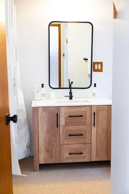 a bathroom with a sink and a mirror at First Light - Vintage waterfront with hot tub - One Bedroom in Tofino
