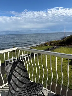 a bench sitting on a balcony looking at the ocean at Jaspers Seaside Resort complex, in Courtenay