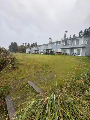 a large grass field in front of a building at Jaspers Seaside Resort complex, in Courtenay