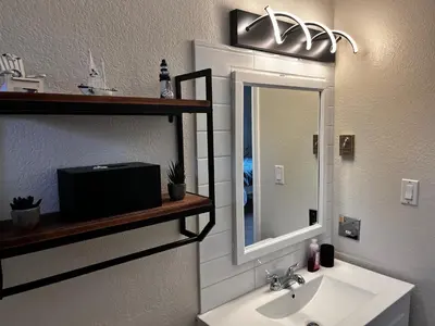 a bathroom with a sink and a mirror at Jaspers Seaside Resort complex, in Courtenay