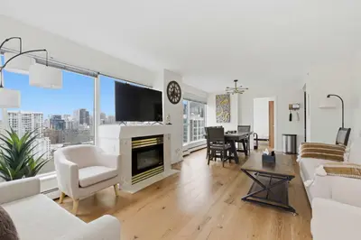 a living room with white furniture and a large window at Downtown Skyline Suite with Pool & Sauna in Vancouver