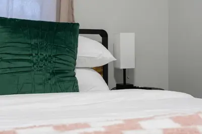 a bed with a green pillow on top of it at The Cabin Sleep in Edmonton