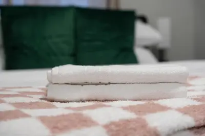 a stack of towels sitting on top of a bed at The Cabin Sleep in Edmonton
