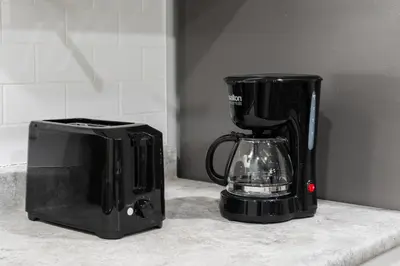 a coffee maker sitting next to a blender on a counter at The Cabin Sleep in Edmonton