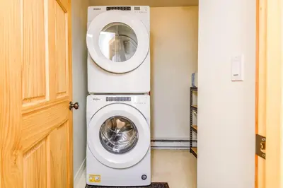 a washing machine in a room next to a door at Alpine Timbers 2 Luxury Chalet with Hot Tub in Big White