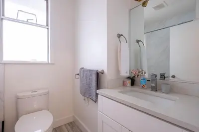a white bathroom with a toilet and a sink at Quiet 5 BR 7 bed Escape with sunny Deck near UBC in Vancouver