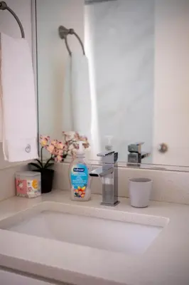 a bathroom counter with a sink and a mirror at Quiet 5 BR 7 bed Escape with sunny Deck near UBC in Vancouver