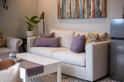 a living room with a white couch with purple pillows at Luxury Modern 2-Bedroom Suite Near Transit & Shops in White Rock