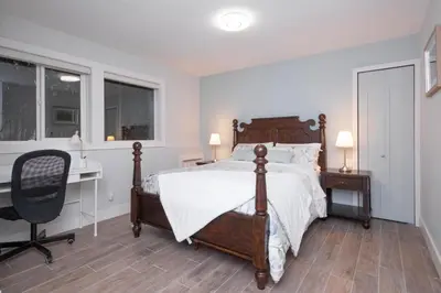 a bedroom with a bed and a desk and a chair at Luxury Modern 2-Bedroom Suite Near Transit & Shops in White Rock